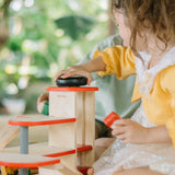 Child using the wind up lift on the PlanToys wooden city parking garage. 