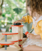 Child using the wind up lift on the PlanToys wooden city parking garage. 
