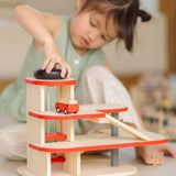 Child playing with the PlanToys wooden city parking garage using the wind up vehicle working lift