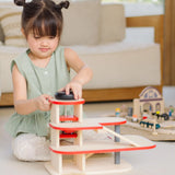 Child playing with the wind up lift on the PlanToys wooden city parking garage. 
