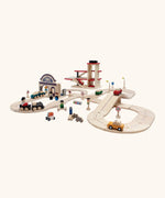 PlanToys city transit with rail and road playset showing different wooden vehicles on the rail and road pieces with a car park in the background