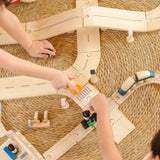 Overhead view of children playing with the PlanToys wooden city transit rail and road playset