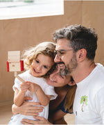 Child holding a seflie stick with a camera from the PlanToys vlogger kit taking a family selfie