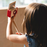 Child holding a camera on a selfie stick from the PlanToys pretend vlogger kit