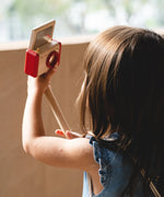 Child holding a camera on a selfie stick from the PlanToys pretend vlogger kit