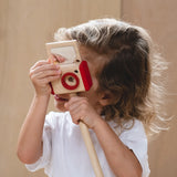 Child looking through a camera from the PlanToys vlogger kit