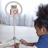 Child setting up the ring light and camera from the PlanToys pretend vlogger kit