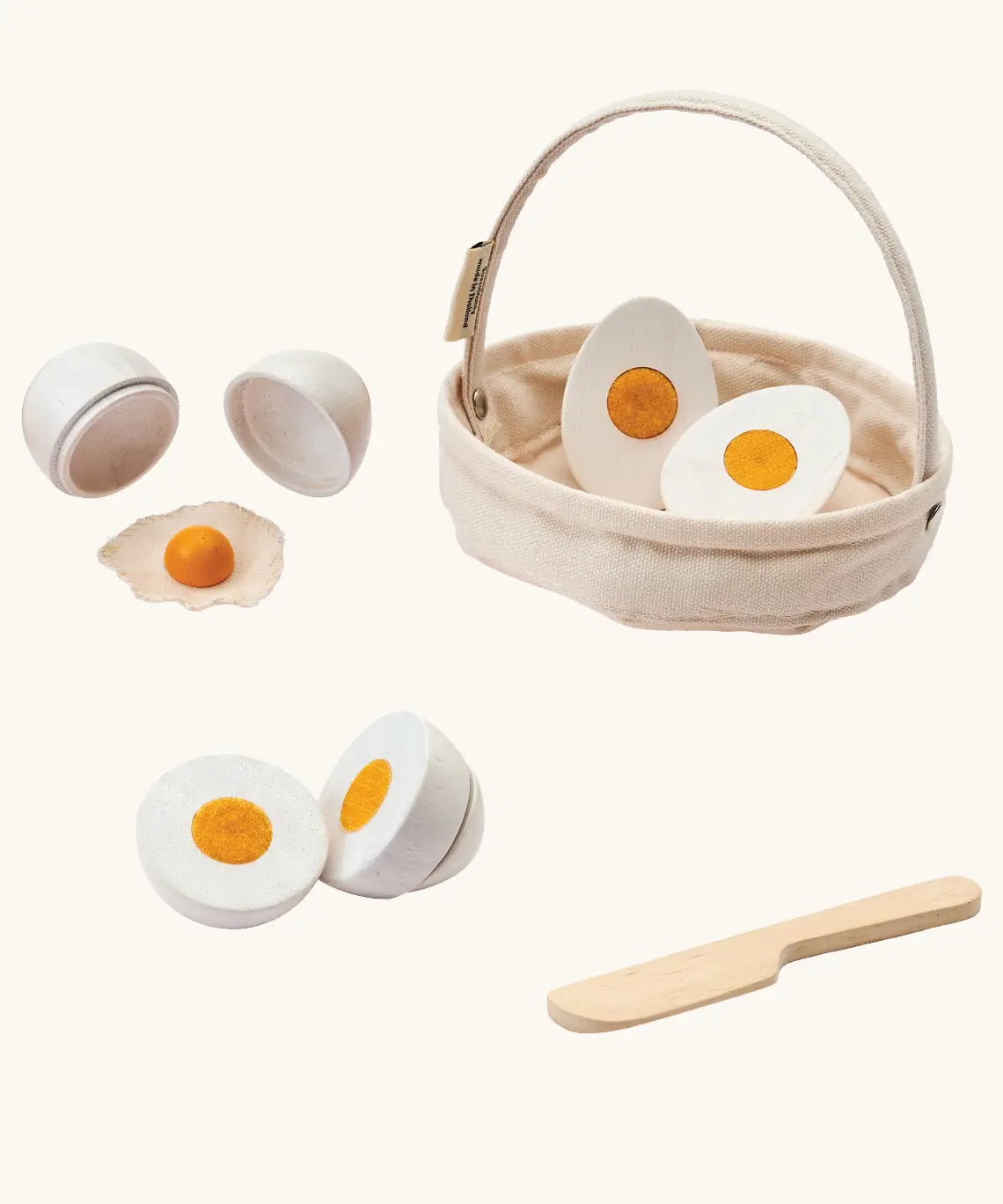 PlanToys crack & cook egg basket set. Showing 3 different types of white eggs to cut and a wooden knife