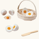 PlanToys crack & cook egg basket set. Showing 3 different types of white eggs to cut and a wooden knife