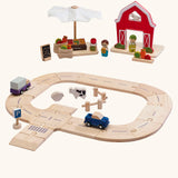 PlanToys wooden farm to market roadway playset. Features a market, farm set, road pieces and vehicles