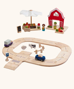 PlanToys wooden farm to market roadway playset. Features a market, farm set, road pieces and vehicles