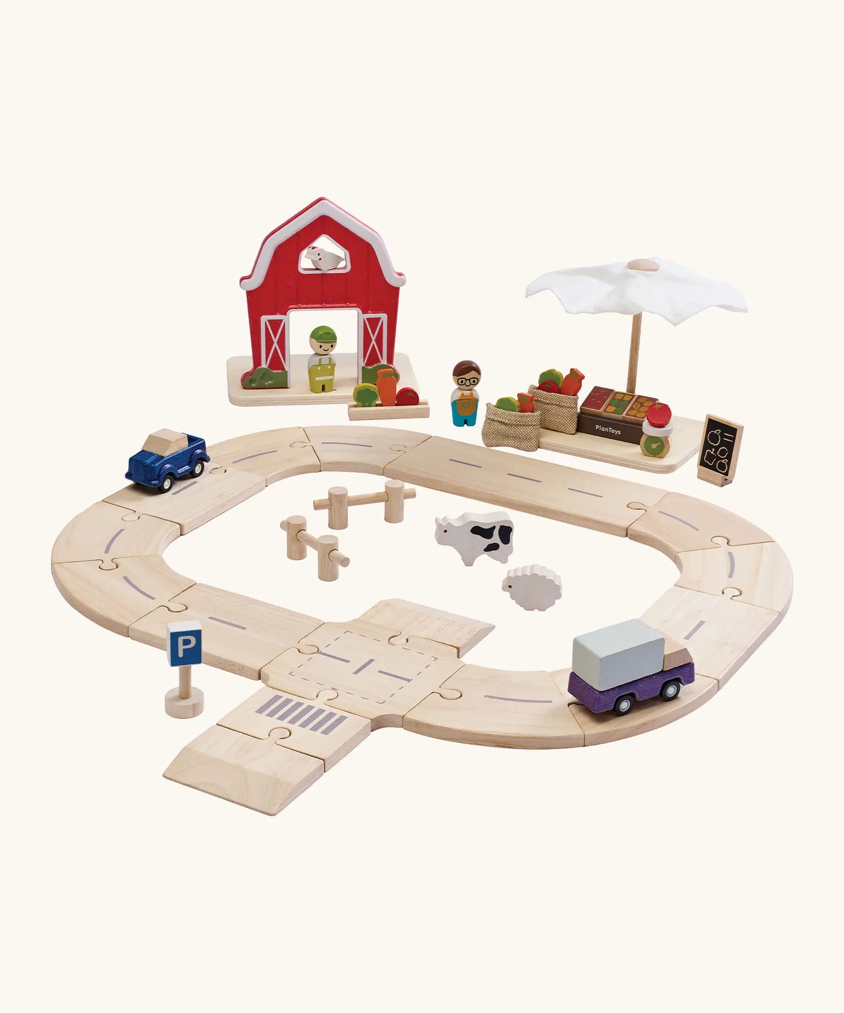 PlanToys wooden roadway with farm animals in the middle. Showing the market and farm set standing behind