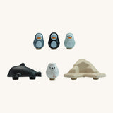 Pieces of the plan toys plastic free finding penguin family board game lined up on a white background