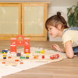 Child leaning over a Child playing with the PlanToys fire & rescue roadway set on a rug