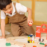 Child playing with the PlanToys fire & rescue roadway set holding a red fire engine 