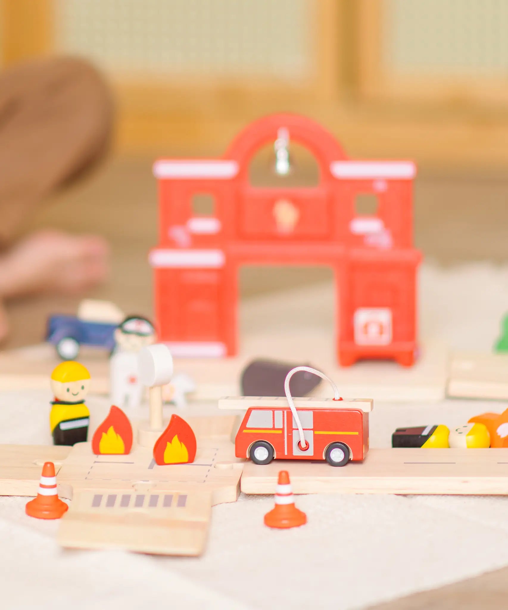 PlanToys fire & rescue roadway set showing a close up of a fire engine, emergency people figures and a fire station in the background