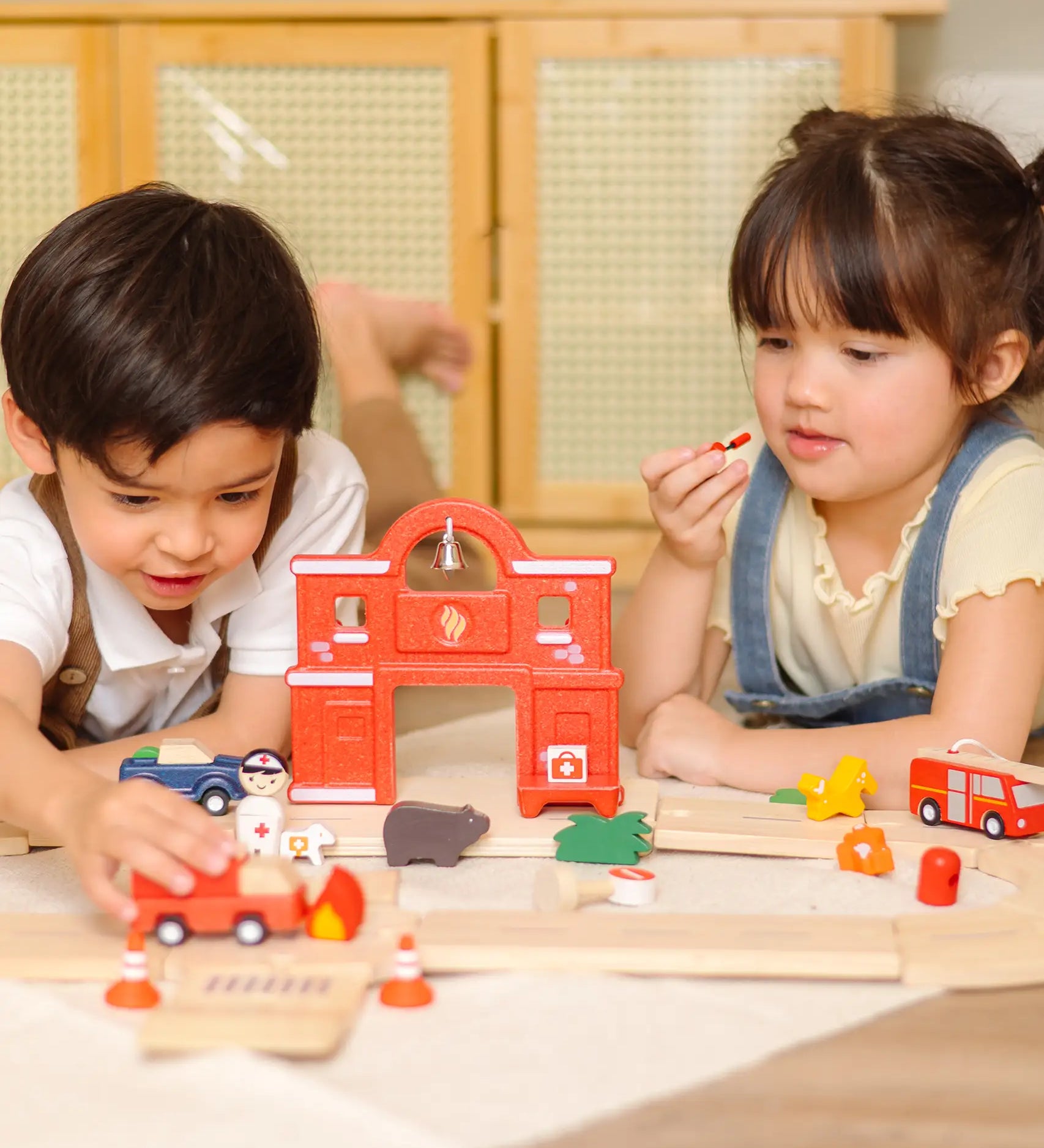 Children playing with the PlanToys fire & rescue roadway set