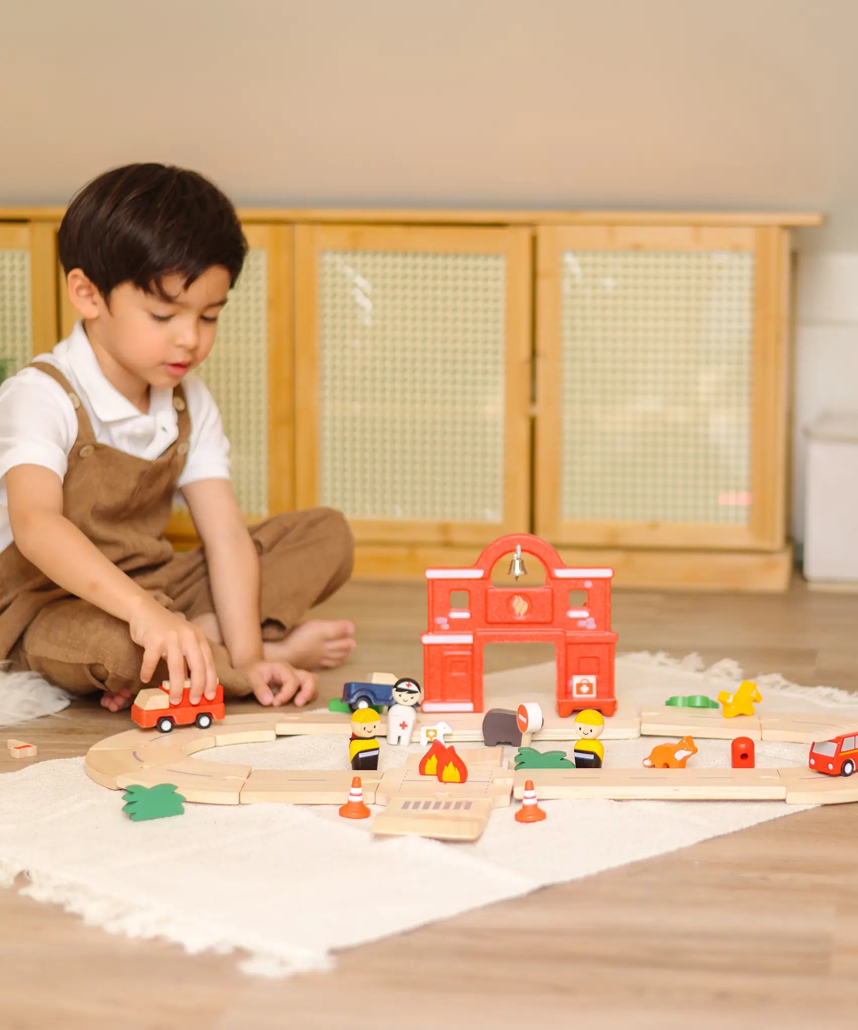 Child playing with the fire engine on the road from the PlanToys fire & rescue roadway set 