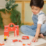 Child playing with loose figures with the PlanToys wooden fire station extension set