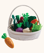 PlanToys basket with loose wooden veggies inside showing a loose carrot in  front