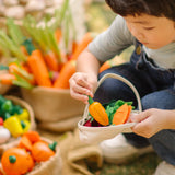Child filling a PlanToys basket with loose wooden veggie pieces