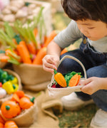 Child filling a PlanToys basket with loose wooden veggie pieces