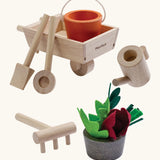 PlanToys garden wheelbarrow set showing garden tools and a bucket with loose veg