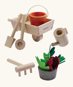 PlanToys garden wheelbarrow set showing garden tools and a bucket with loose veg