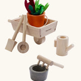 PlanToys wooden wheelbarrow set with garden tools and a bucket with loose veg