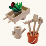 PlanToys wooden wheelbarrow with garden tools and a bucket with loose veg