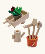 PlanToys wooden wheelbarrow with garden tools and a bucket with loose veg