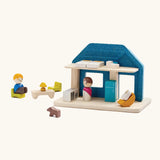 Back o  PlanToys wooden blue house set showing the included small furniture and figures