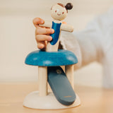 Child inserting the PlanToys gymnast peg doll in the base ready to be launched. 