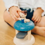 Child pushing the PlanToys gymnast peg doll inside the base ready to be launched