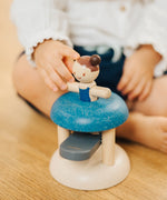 Child pushing the PlanToys gymnast peg doll inside the base ready to be launched