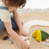 Children holding loose road pieces from the PlanToys wooden jungle explorers road playset 