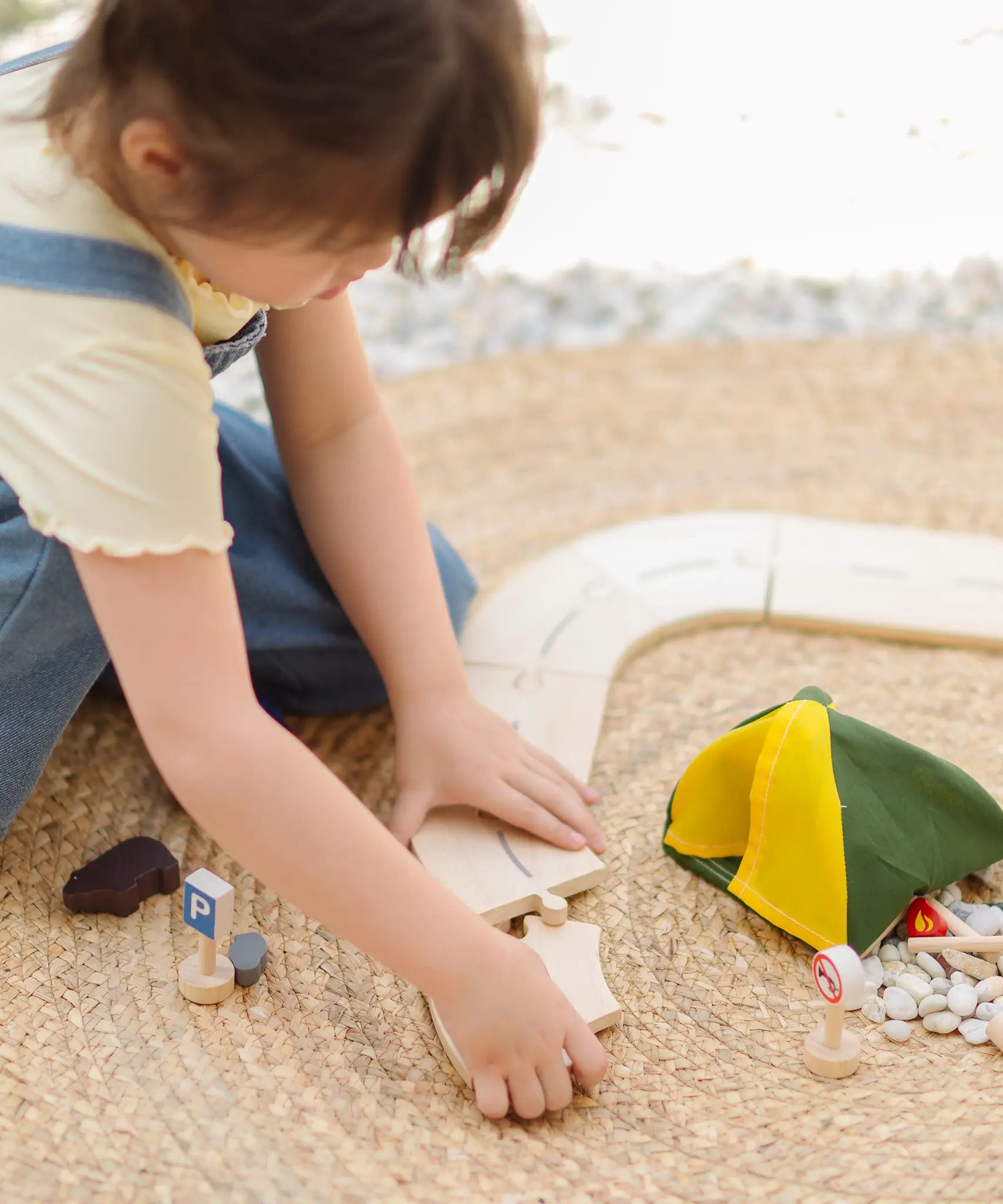 Children holding loose road pieces from the PlanToys wooden jungle explorers road playset 