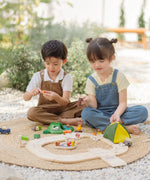 Children playing with the PlanToys wooden jungle explorers road playset 