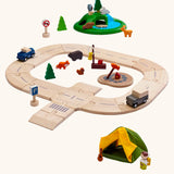 PlanToys play setup using wooden road pieces with cars, a tent and a grassy mount with wooden animal figures