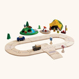 PlanToys play setup showing wooden road pieces with cars, a tent and a grassy mount with wooden animal figures