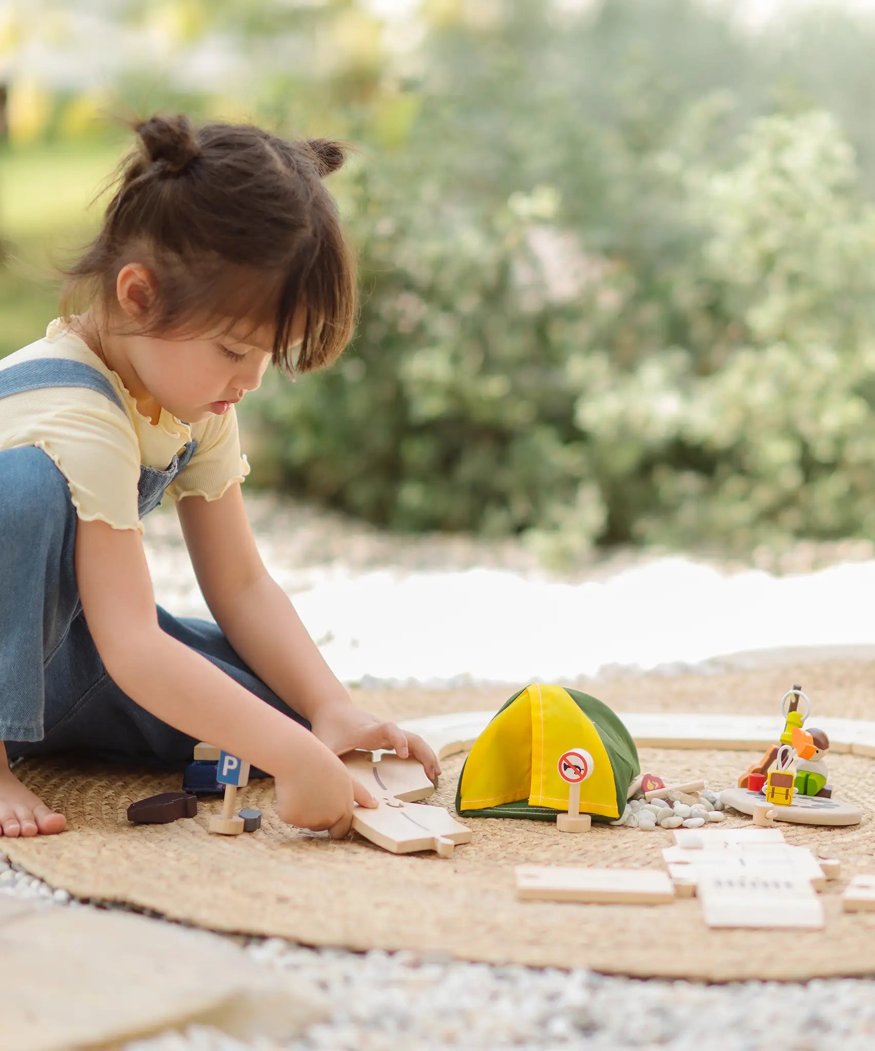 Children assembling loose road pieces from the the PlanToys wooden jungle explorers road playset 