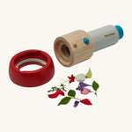 The PlanToys Kaleidoscope, with its red lens detached and flowers to the side, to show where to put the small objects that are to be looked at. The image is on a cream background