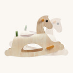 The PlanToys Palomino Rocking Horse rocking back and forth on a cream background