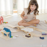 PlanToys little wooden neighbourhood roadway set up on a white blanket