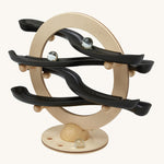 The PlanToys Curvy Click Clack game is a wooden marble run toy with a circle base and 4 wobbly tracks all made from PlanWood. The image shows marbles going down the track on a cream background