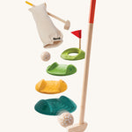 The PlanToys Mini Golf Game is a fun and sensory set, which Includes 2 wooden kids-sized golf clubs, 3 challenge tracks, 2 balls, 1 hole and a handy bag. Each track piece has a different texture on the top. The image is on a cream backgorund