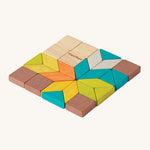 PlanToys Mini Mosaic Blocks in different shapes, sizes and colours, on a cream background. The mosaic tiles are in natural wood, blue, orange, green, yellow, brown and grey. The tiles are in the shapes of squares, triangles and rhombus