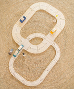 Overhead view of PlanToys rails and road pieces connected together with vehicles on top