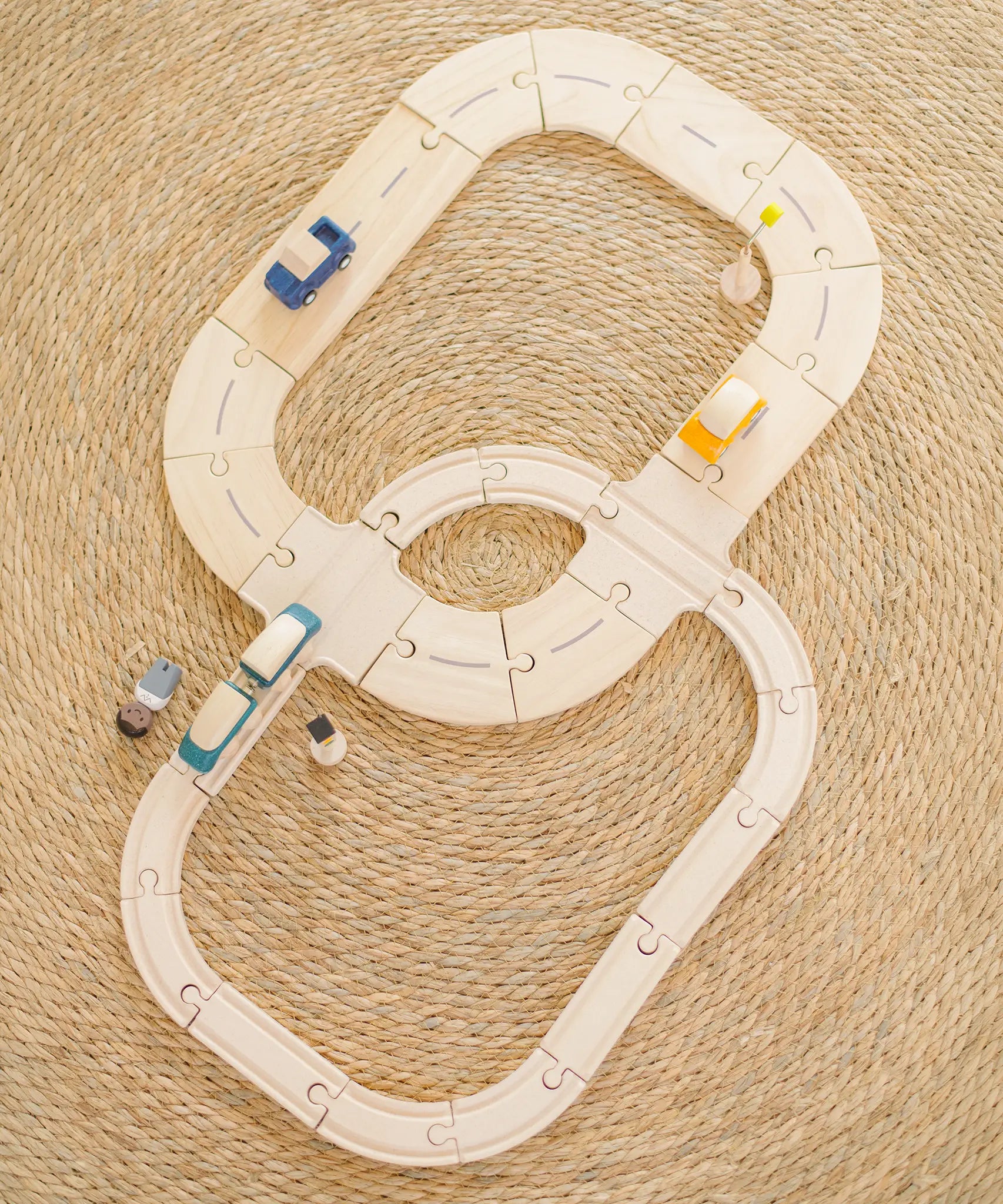 Overhead view of PlanToys rails and road pieces connected together with vehicles on top