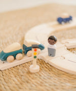 PlanToys my first rail road play set showing a close up of the train with magnetic connectors and a wooden man figure